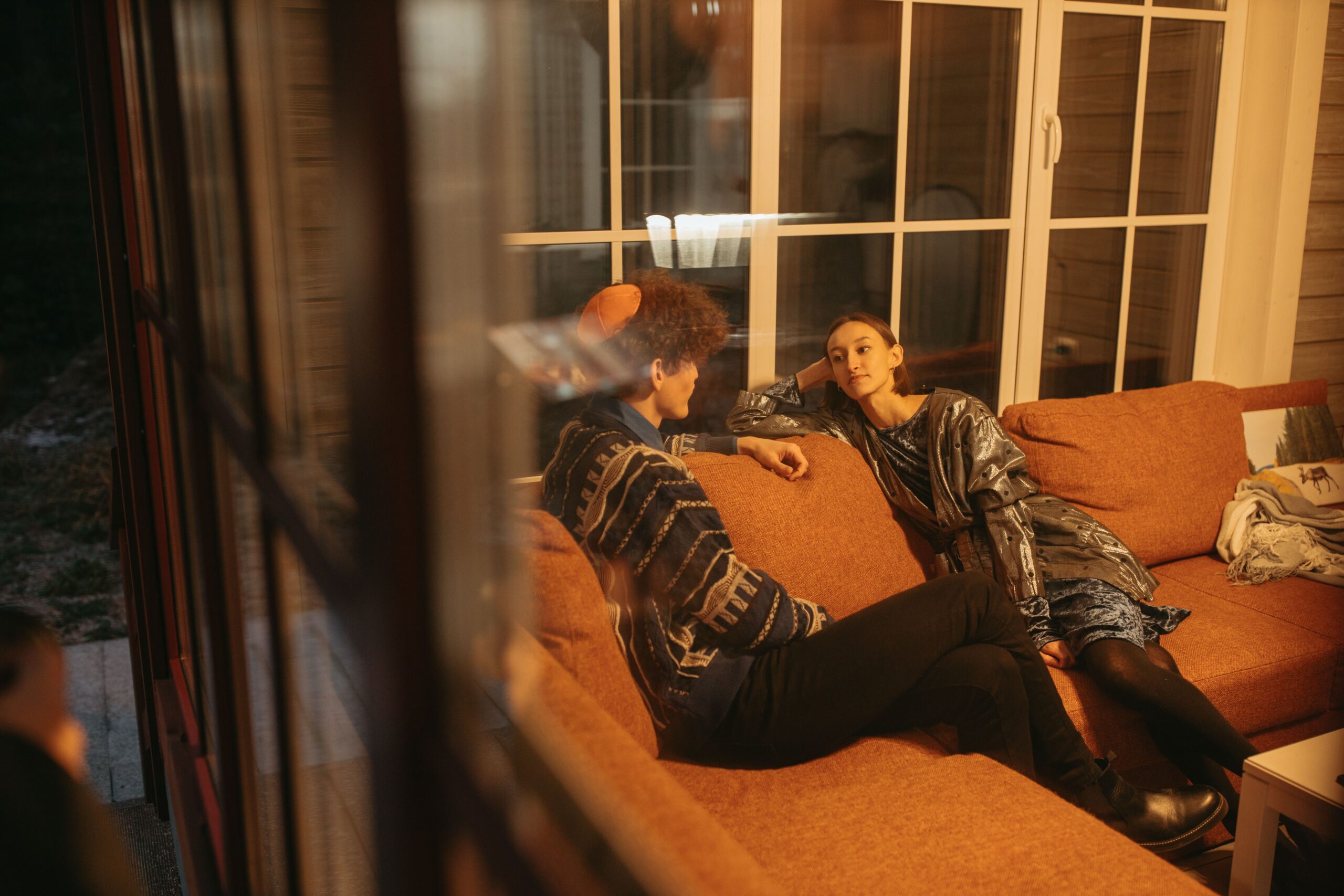 A man and a woman talking while sitting on a couch